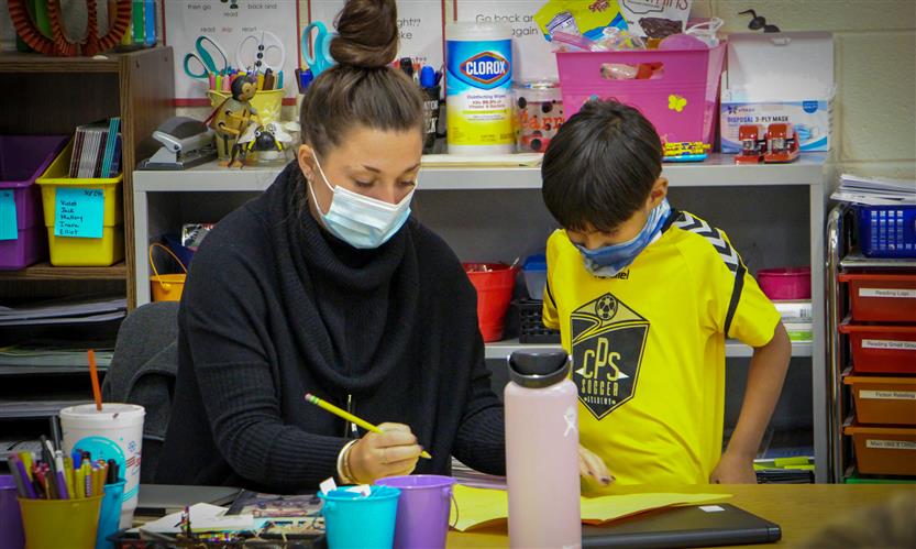 Teacher helps student create thank you card